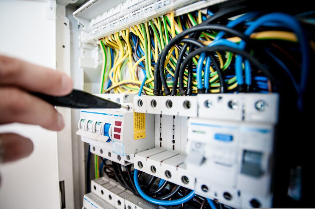 Home electrical load calculator guide showing circuit breaker panel for US homes